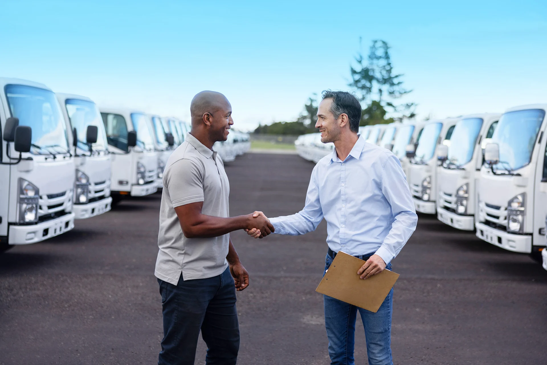 two people meeting for fleet advisory surrounded by fleet of trucks